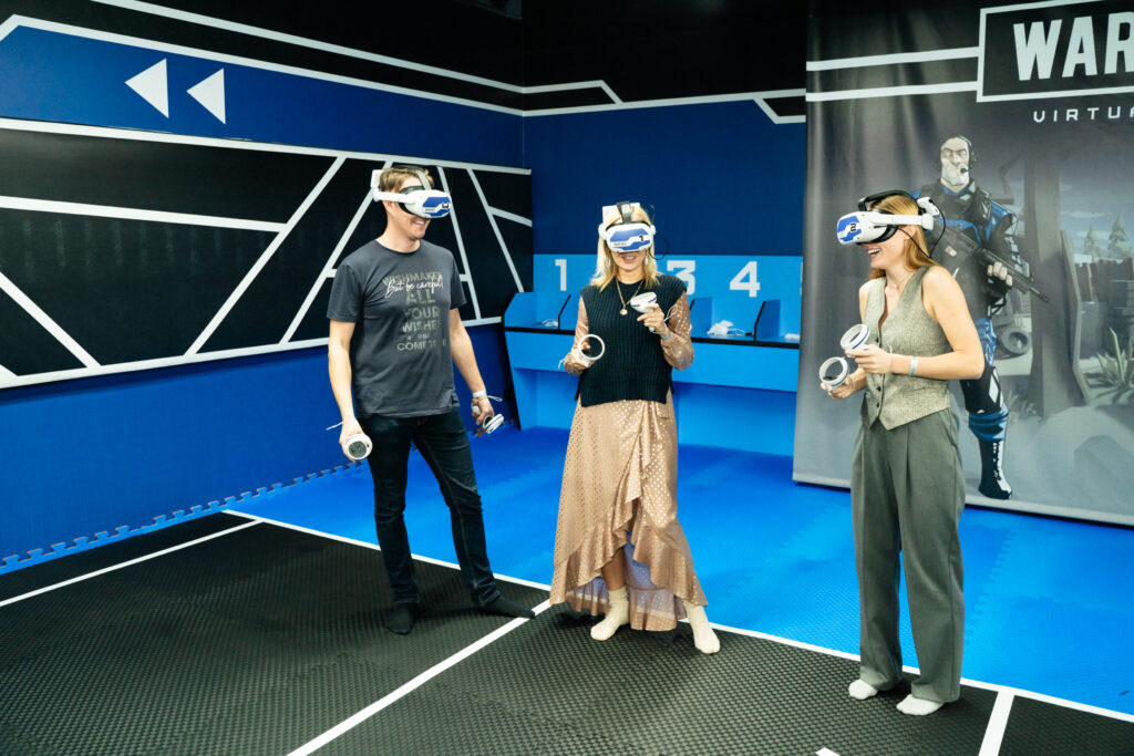 Группа друзей или коллег в VR-шлемах, играющих в VR-клуб в Пензе, демонстрирующая веселый и удивительный отдых